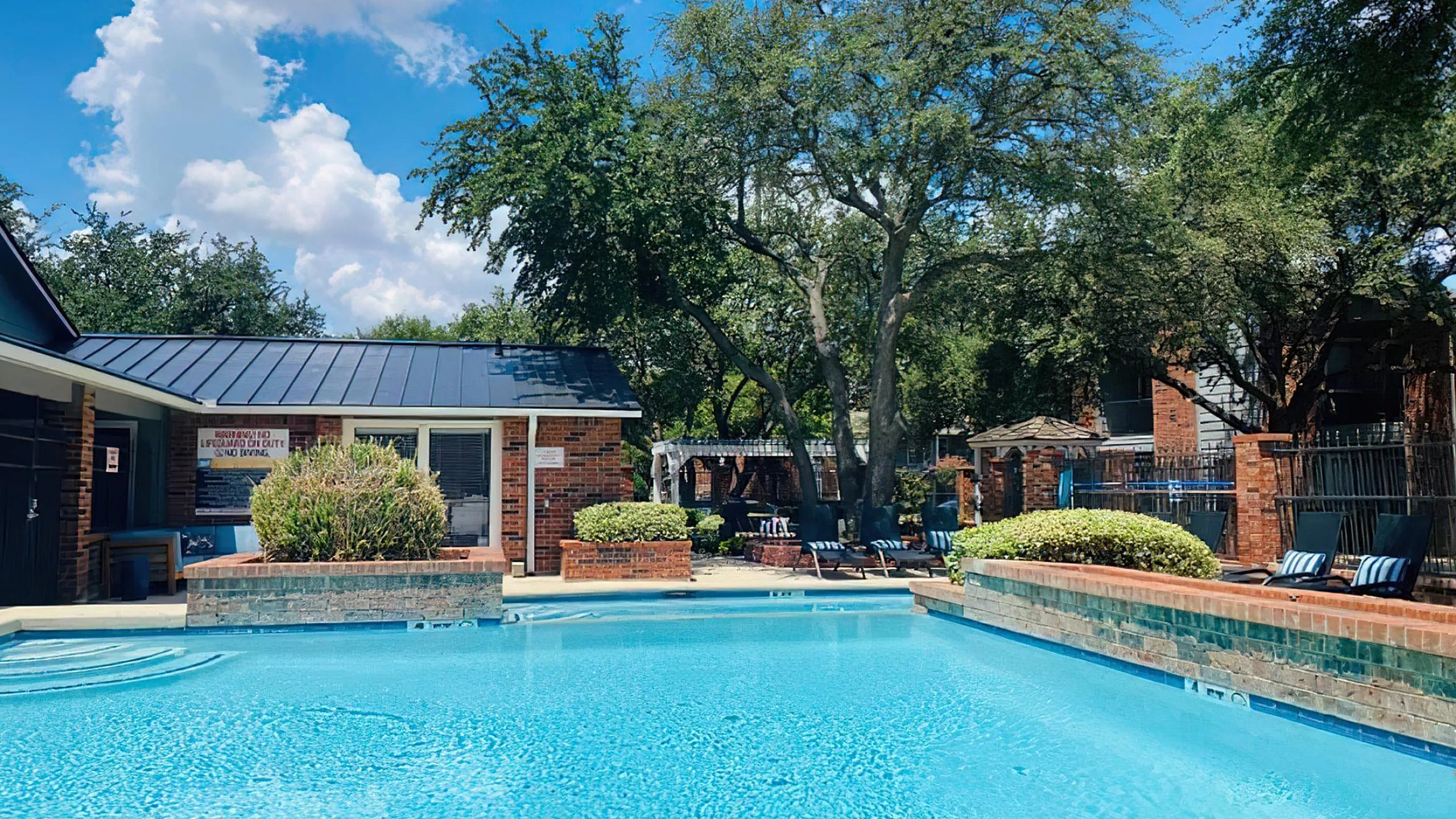 Inviting outdoor pool area with lush greenery and comfortable seating, perfect for relaxation and leisure.