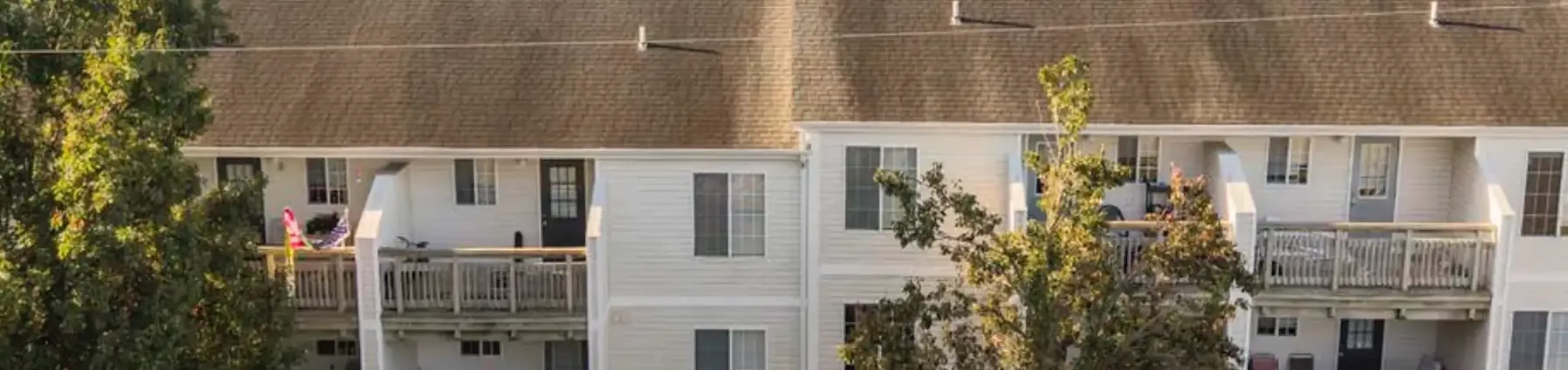 A drone image of the property, which shows the balconies and landscaping behind the building, along with the peaceful nature surrounding the property.