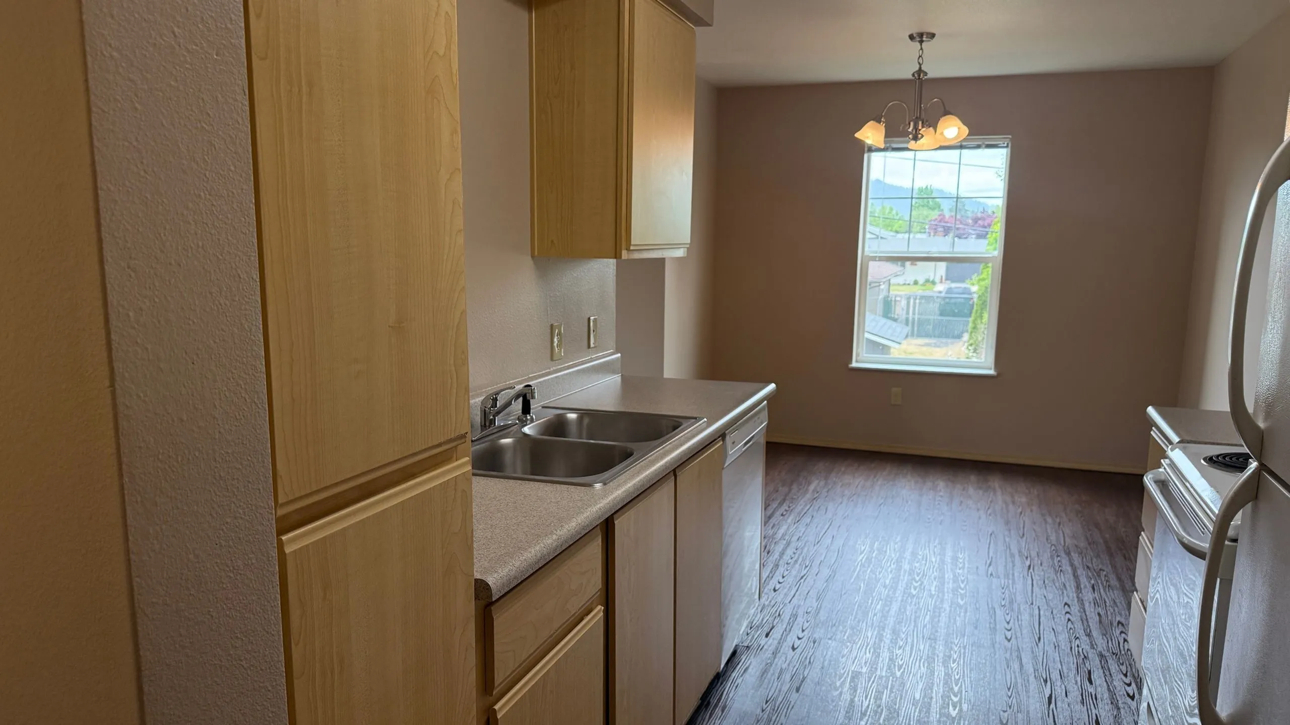 Bright kitchen area with modern countertops, abundant natural light, and hardwood flooring, ideal for culinary creativity.