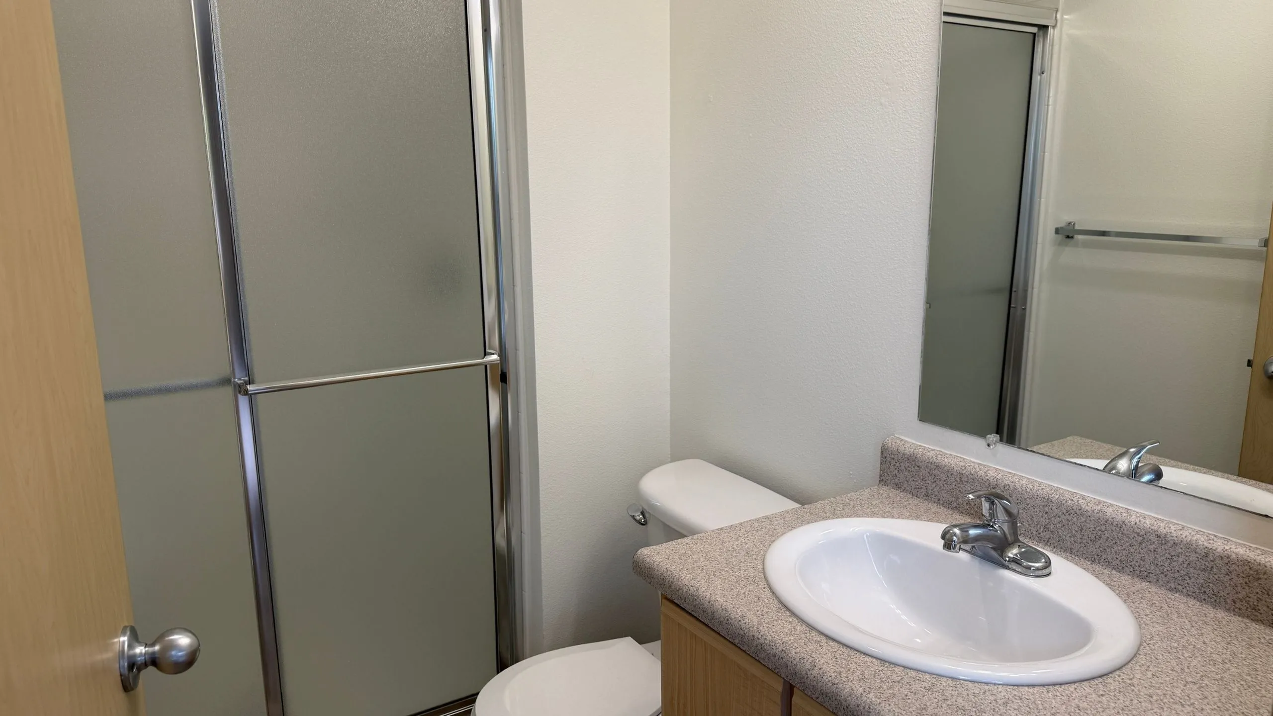 Bright and modern bathroom with a sleek glass shower, elegant sink, and contemporary fixtures.