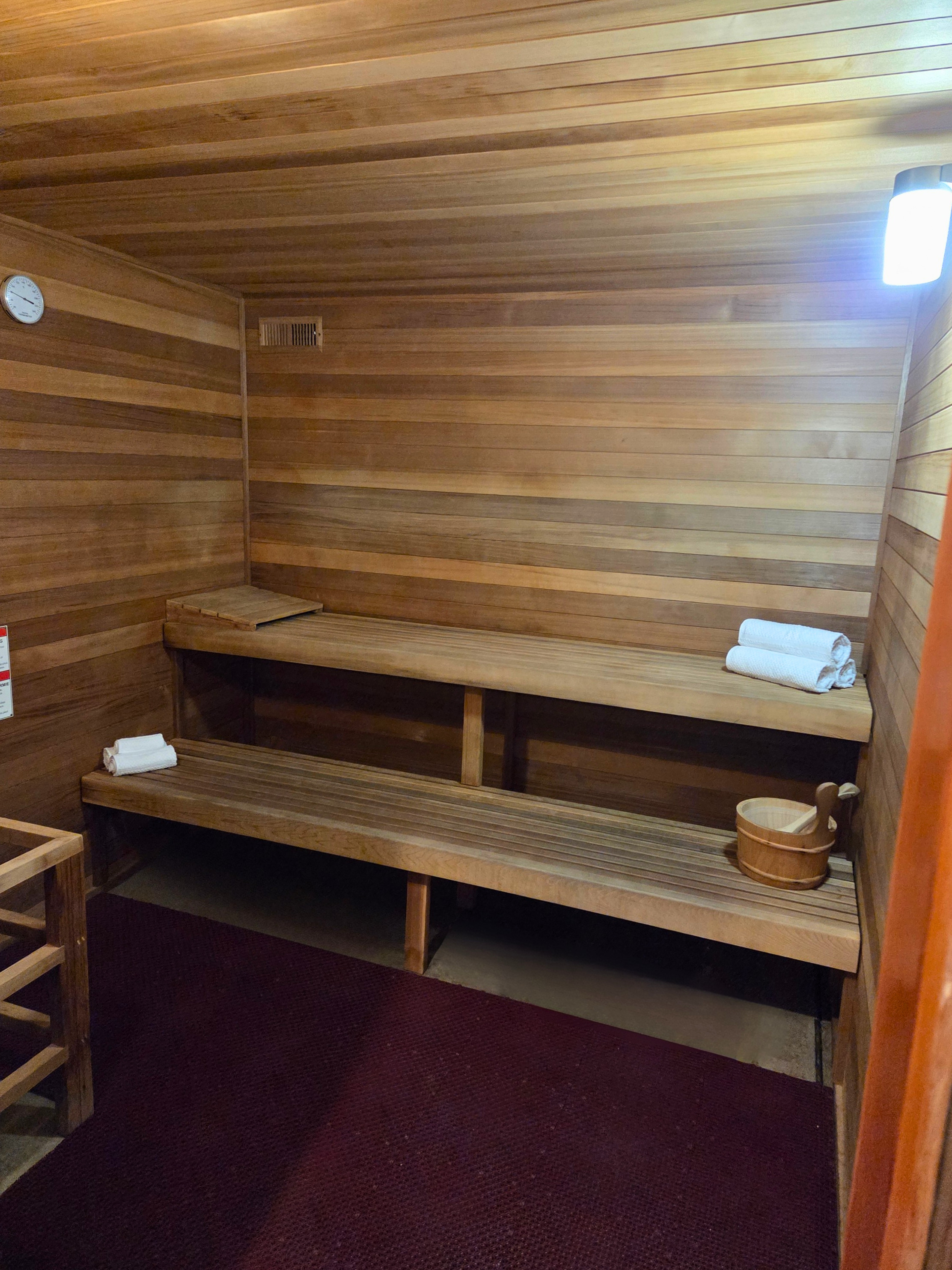 Elegant wooden sauna room with bench seating and cozy ambiance, perfect for relaxation.