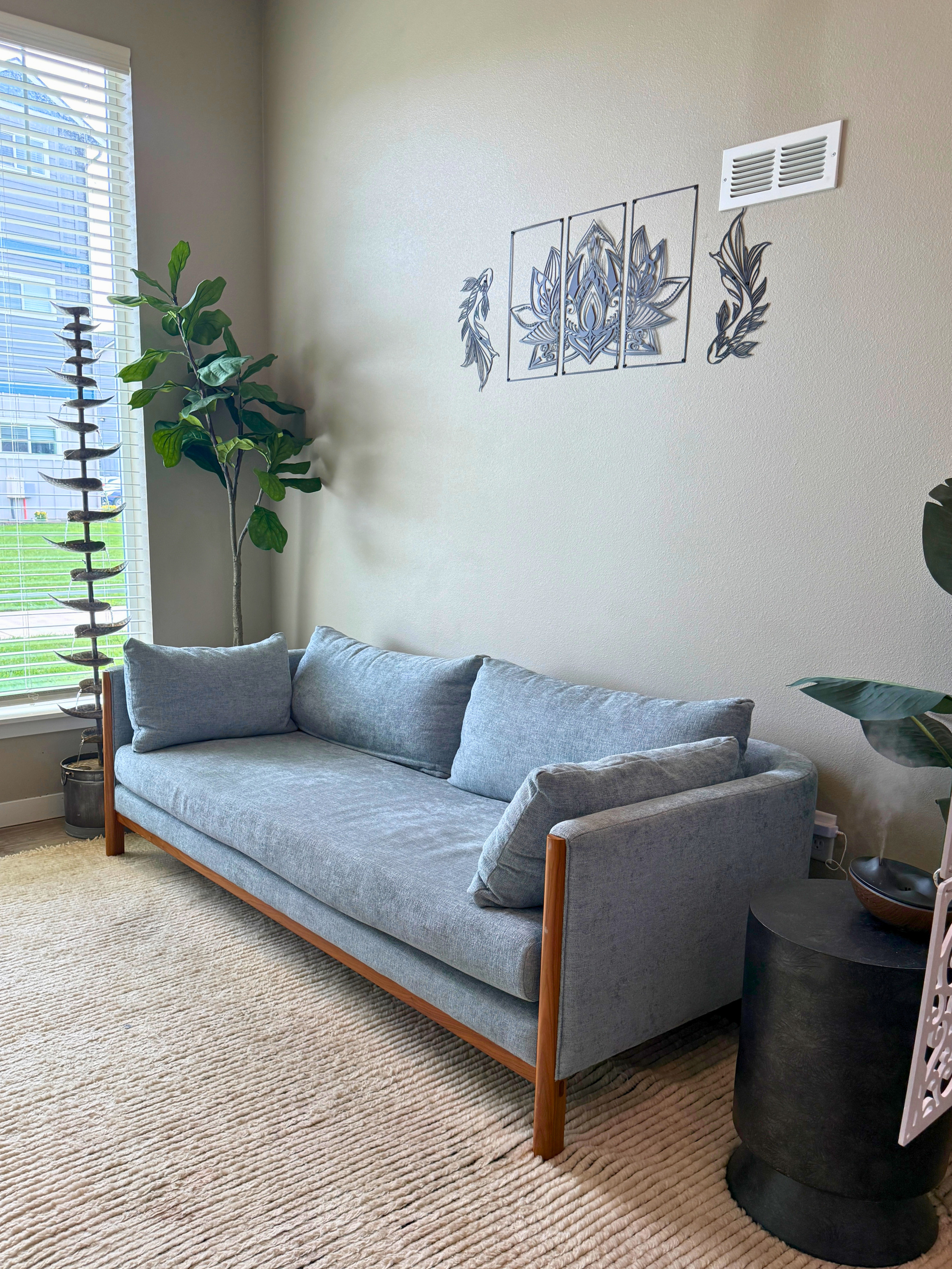 Chic living room with a modern grey sofa, stylish decor, and large window providing natural light.