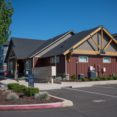 Charming modern community building with rustic architectural style, ample parking, and serene landscaping.