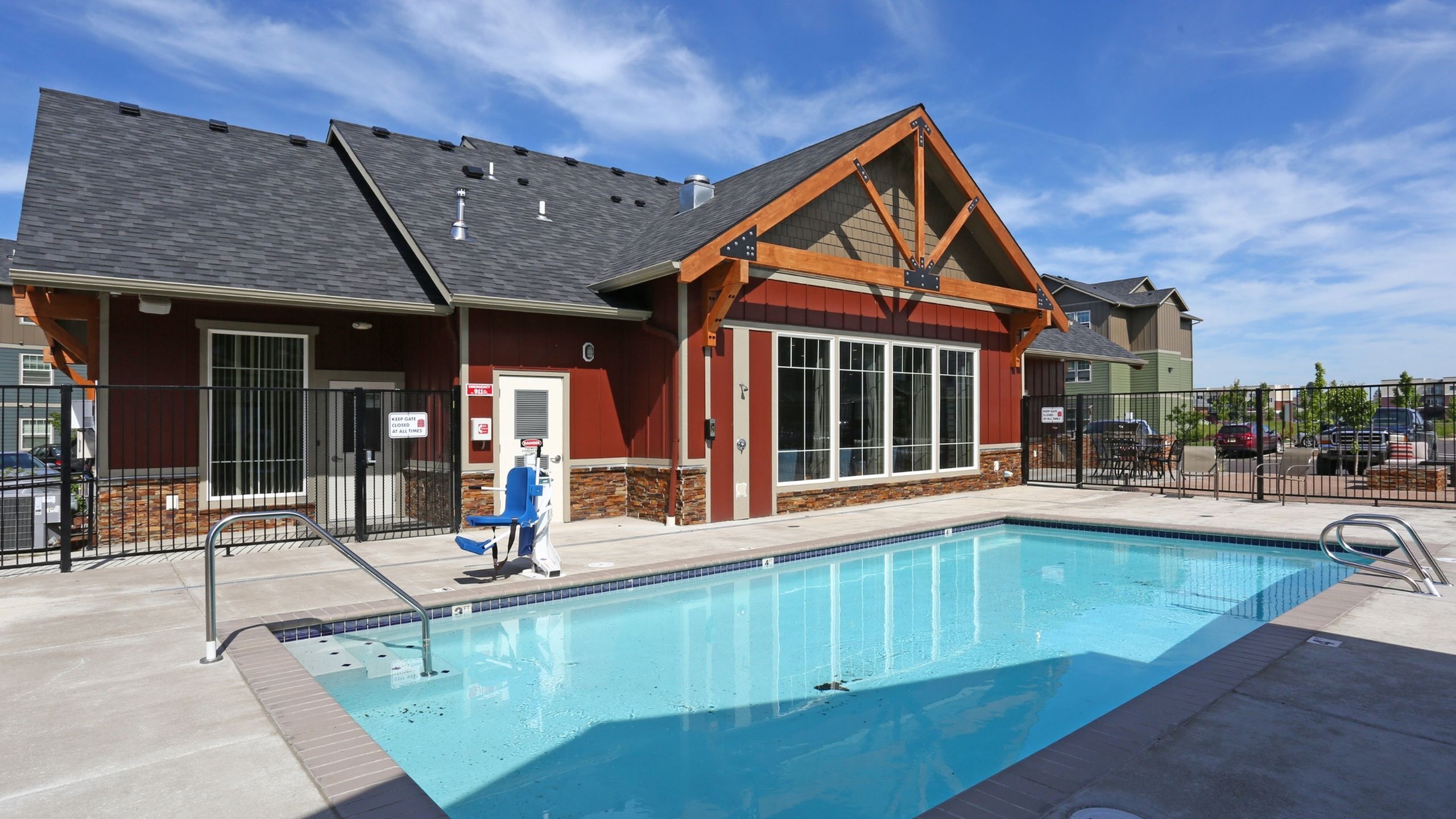 Charming community pool with pristine waters adjacent to a modern clubhouse, ideal for relaxation and social gatherings.