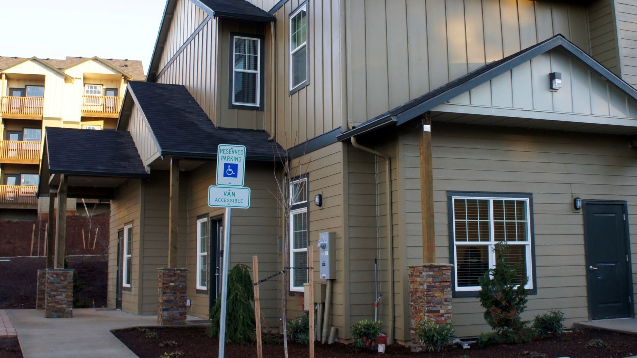 Charming, modern apartment complex with accessible parking, featuring stylish architecture and inviting curb appeal.