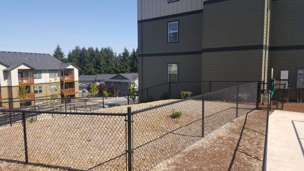 Modern apartment exterior with landscaped surroundings and secure fencing, offering a peaceful and stylish living environment.