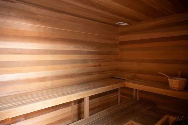 Luxurious wooden sauna with warm lighting, perfect for relaxation and wellness.