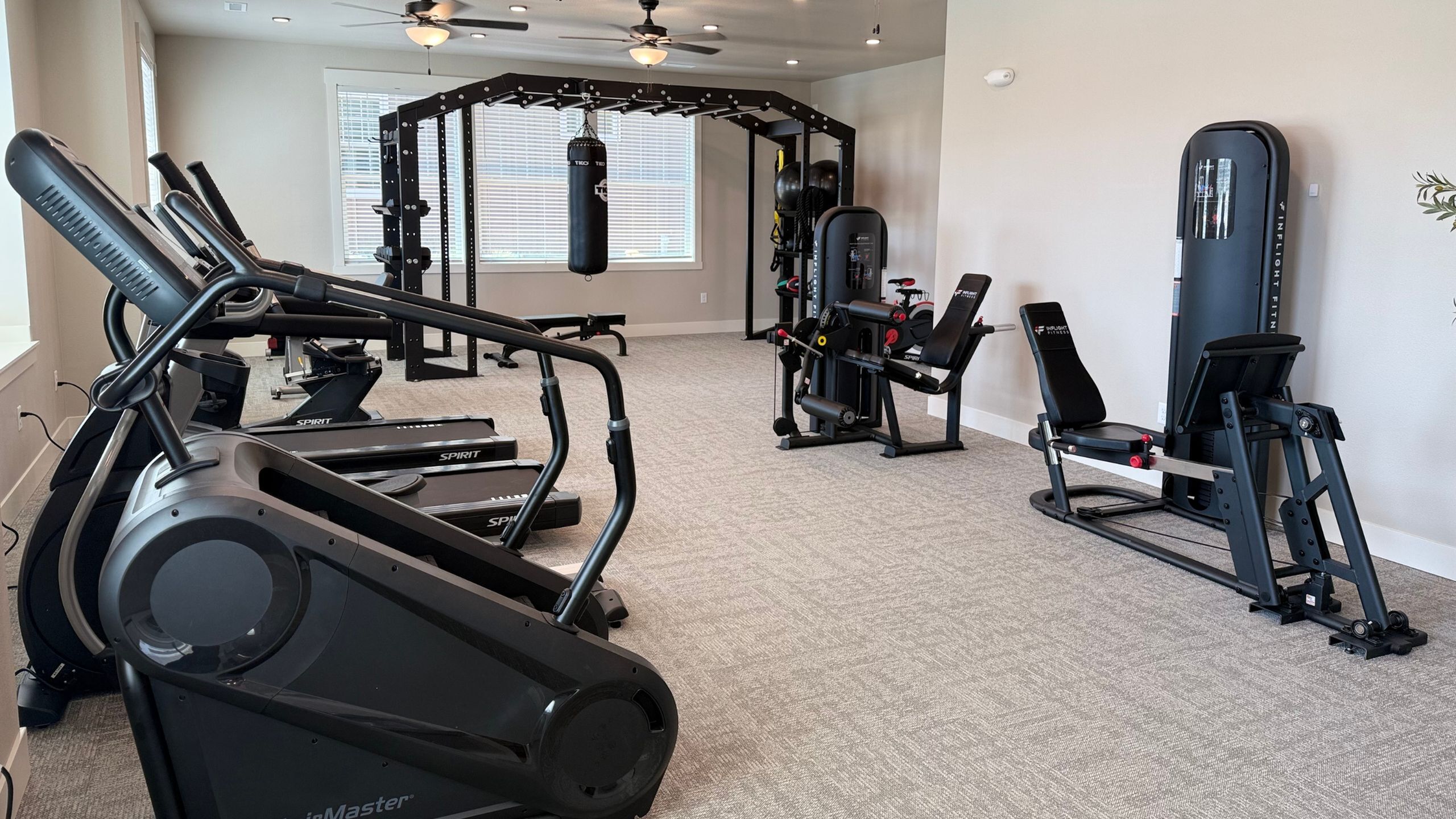 Spacious fitness center with modern exercise equipment, treadmills, and weight training machines in a bright, inviting space.