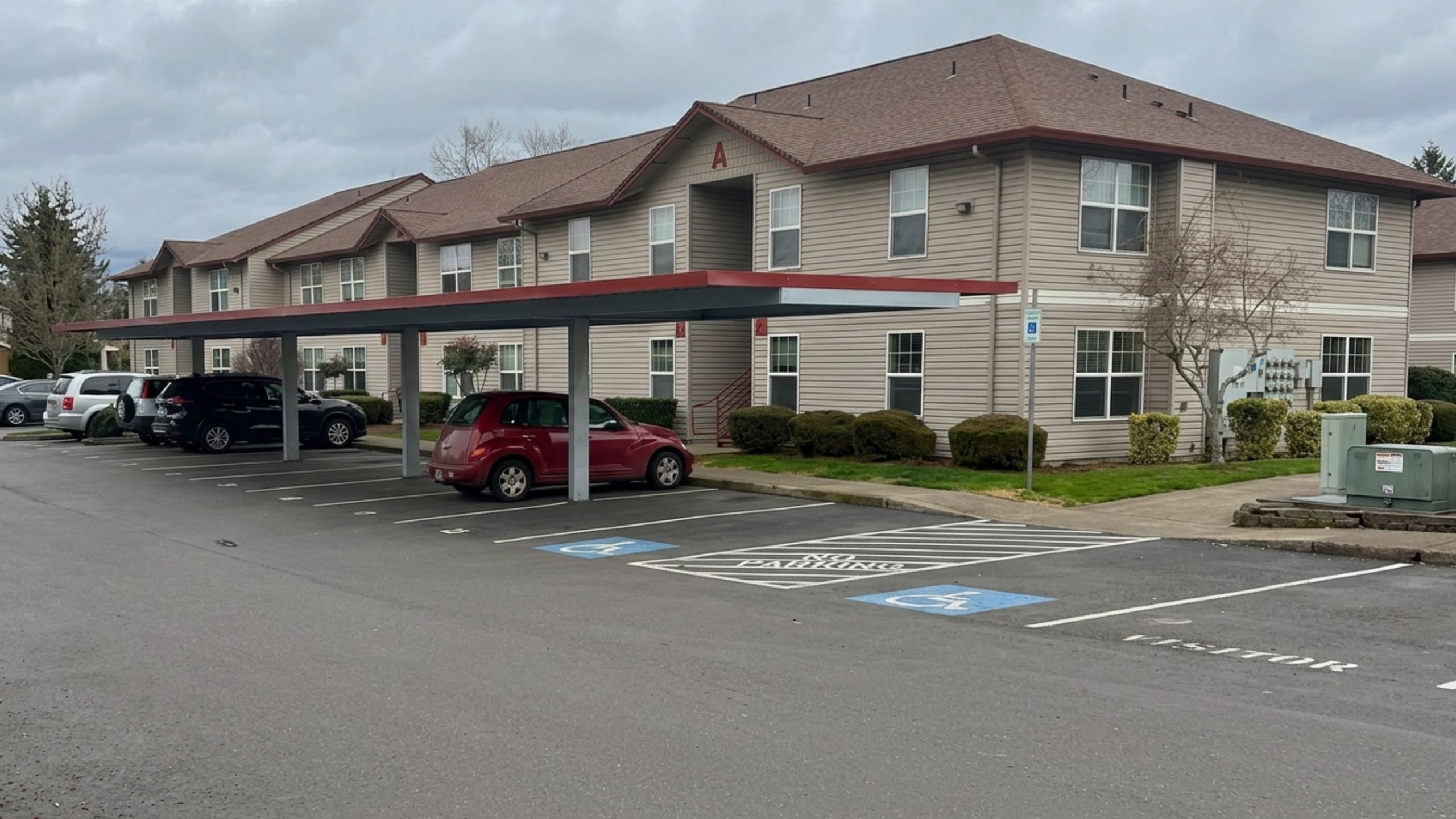 Charming suburban apartment complex with covered parking and well-maintained landscape.