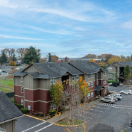 Charming apartment complex with well-maintained landscaping and ample parking, nestled in a picturesque suburban setting.