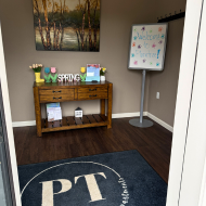Inviting foyer with vibrant spring decor, featuring a wooden console table and a welcoming sign, perfect for creating a warm first impression.