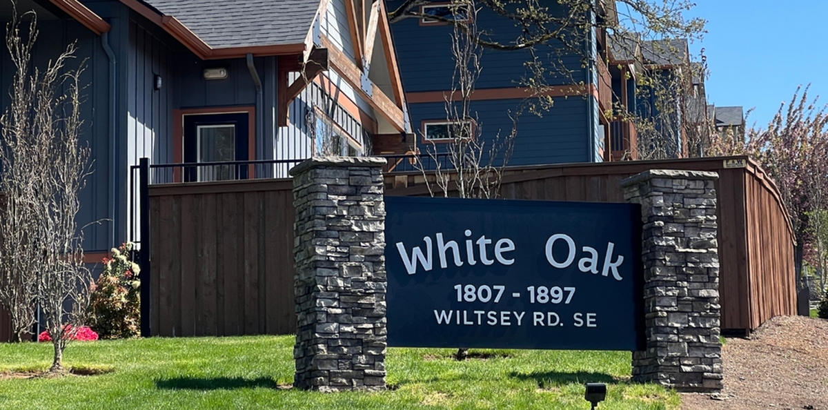 Charming exterior of White Oak apartments, featuring modern architecture and lush green surroundings at Wiltsey Rd. SE.