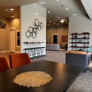 Modern open-concept living space featuring sleek wall decor, comfortable seating, and elegant dining area.