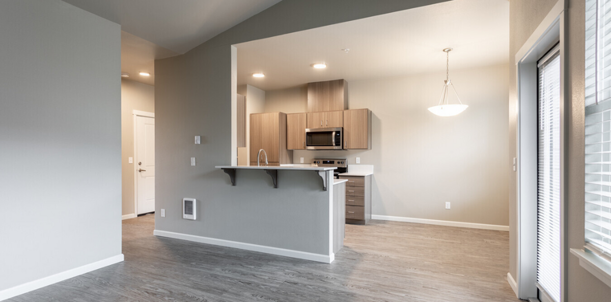 Modern open-plan kitchen with sleek cabinetry, stylish pendant lighting, and ample natural light from large windows.