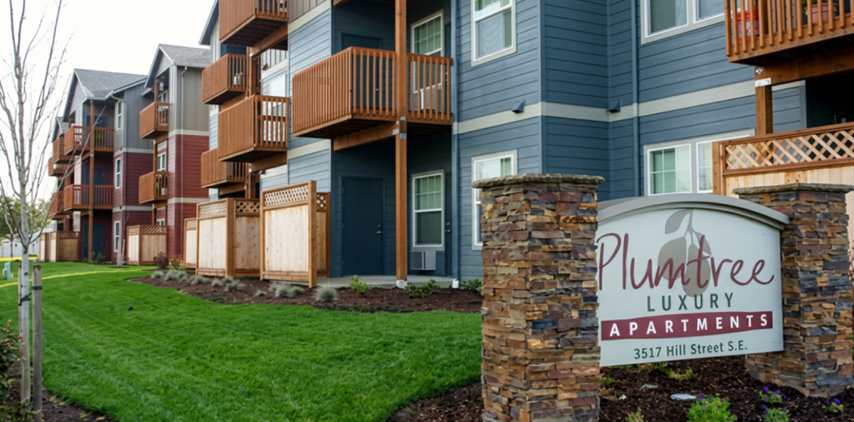 Charming Plumtree Luxury Apartments with stylish modern balconies, lush green lawns, and an inviting facade.