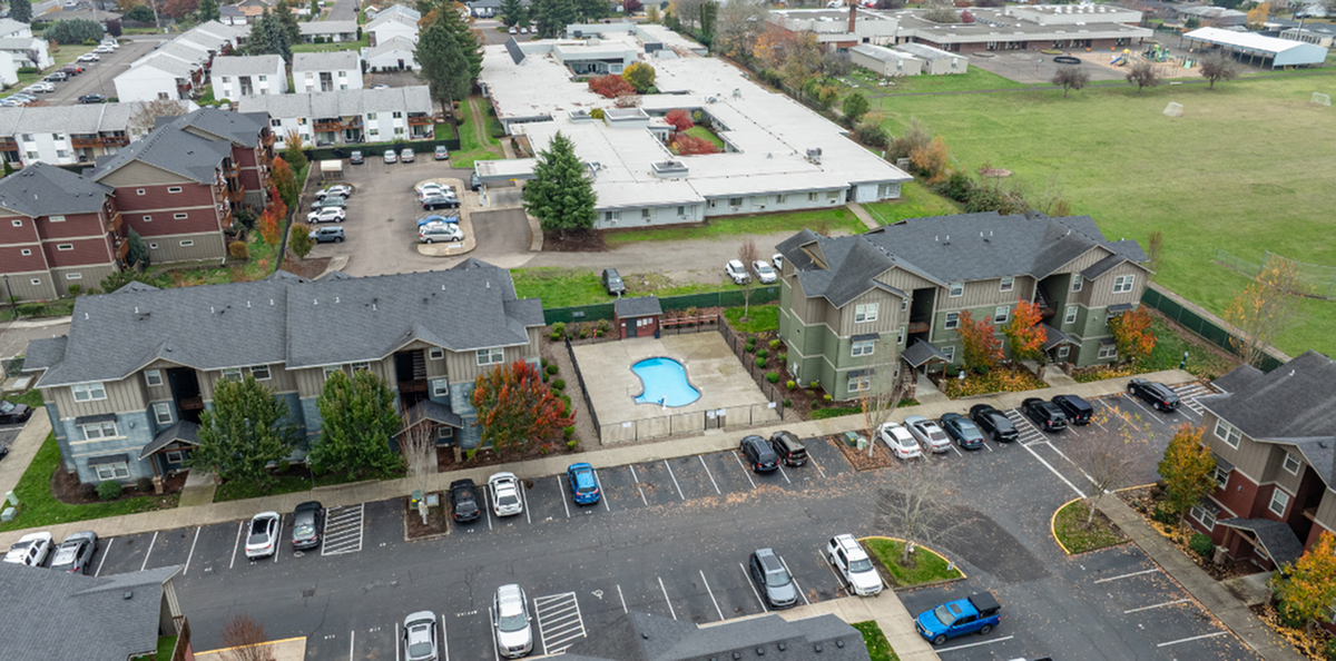 Charming apartment complex with landscaped greenery, community pool, and ample parking space, nestled in a peaceful neighborhood.