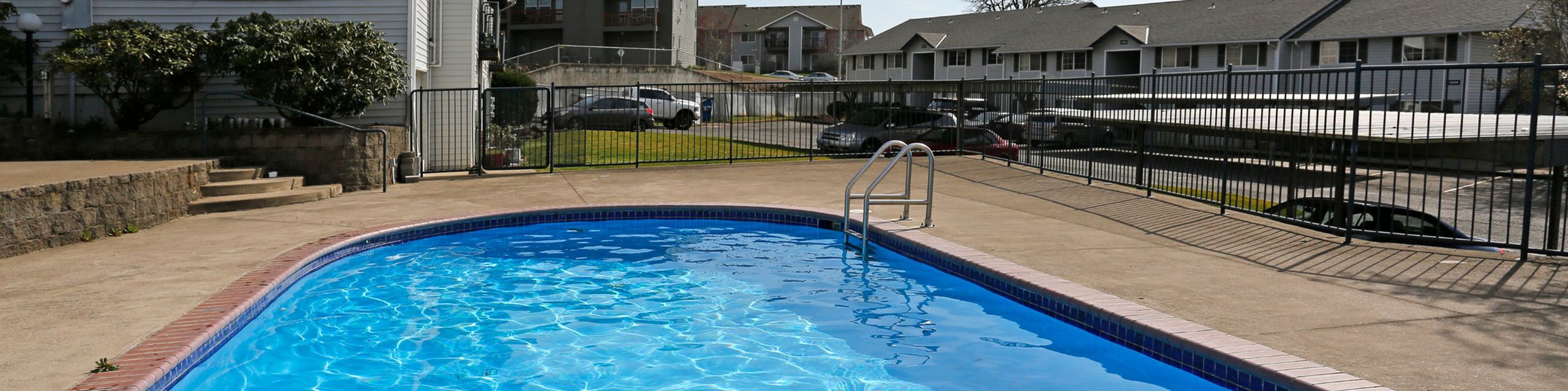 Inviting outdoor pool area with vibrant blue water, surrounded by a spacious deck and secure fencing, perfect for relaxing and enjoying sunny days.