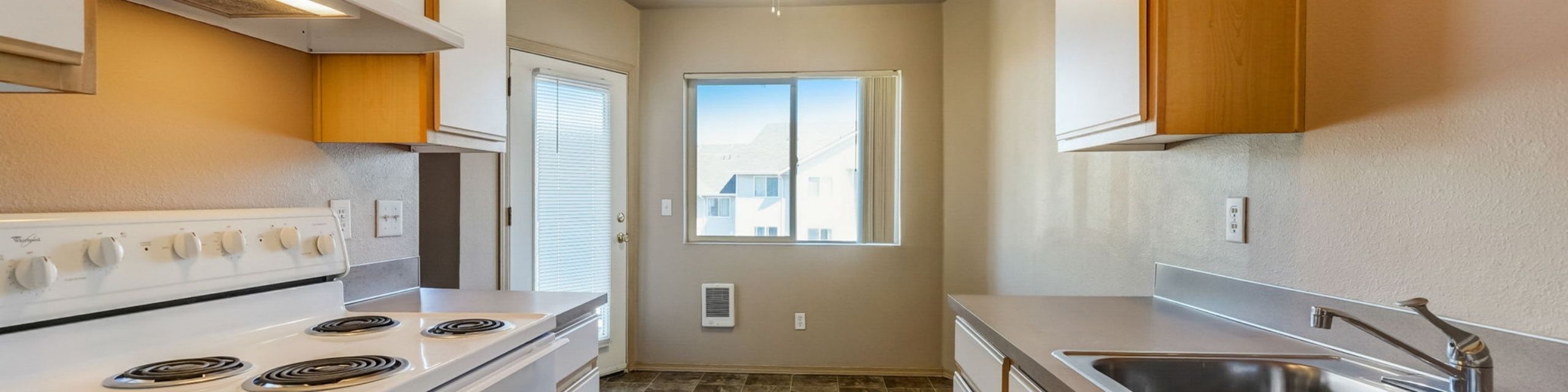 Bright and inviting kitchen with modern appliances, ample cabinetry, and a sunlit window view.