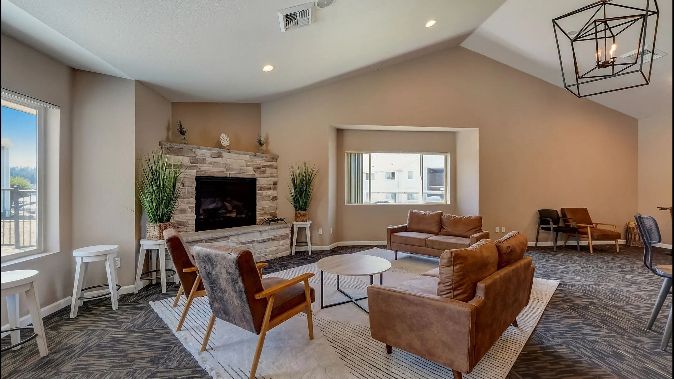 Inviting living room with elegant stone fireplace, plush leather seating, and modern lighting for a cozy yet stylish ambiance.