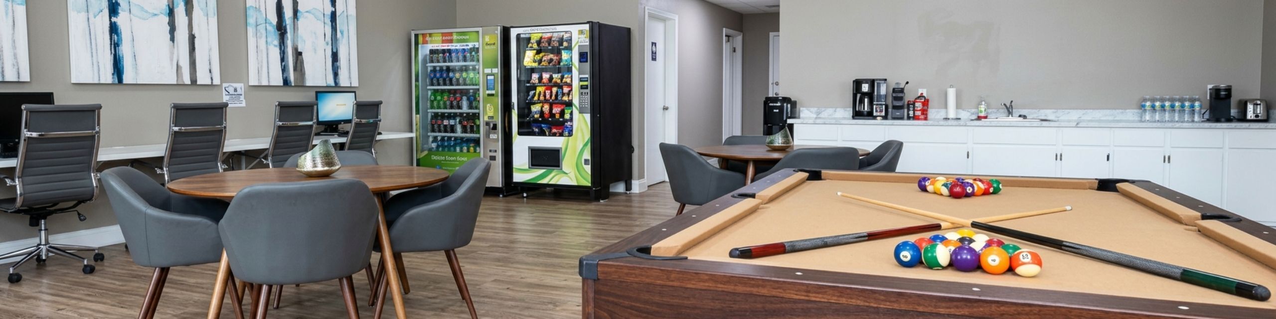 Chic communal lounge featuring a stylish pool table, modern seating, vending machines, and a coffee station for ultimate relaxation and convenience.