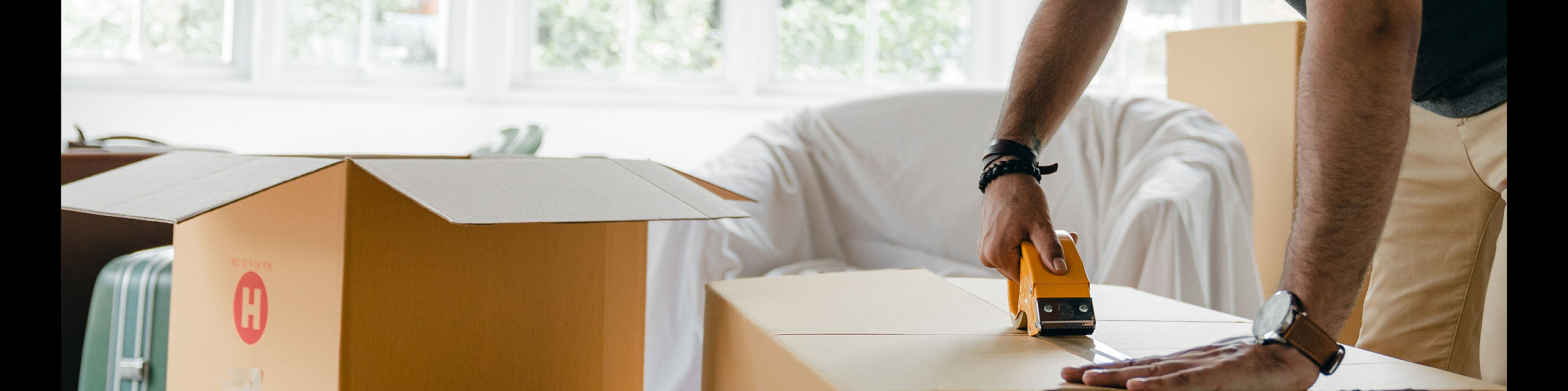 Bright living space with a person packing boxes, ready for a seamless apartment move.