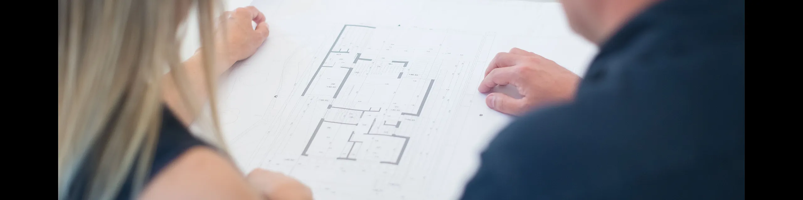 Professionals reviewing a detailed floor plan with focus on innovative design and spacious layout.
