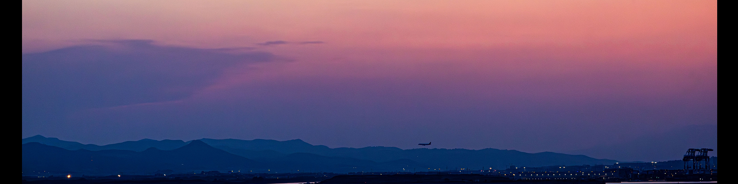 Stunning sunset view with vibrant pink and purple hues over a calm sea, perfect for evening relaxation.