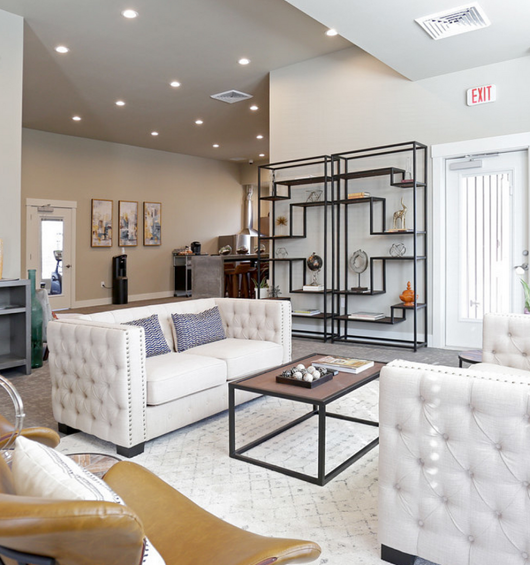 Modern living room with elegant sofas, stylish decor, and a cozy stone fireplace in a bright, open space.
