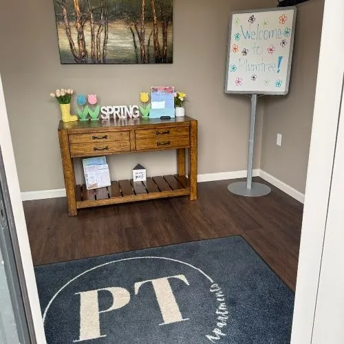 Inviting apartment entrance with a charming welcome sign, rustic wooden console, and vibrant spring decor.