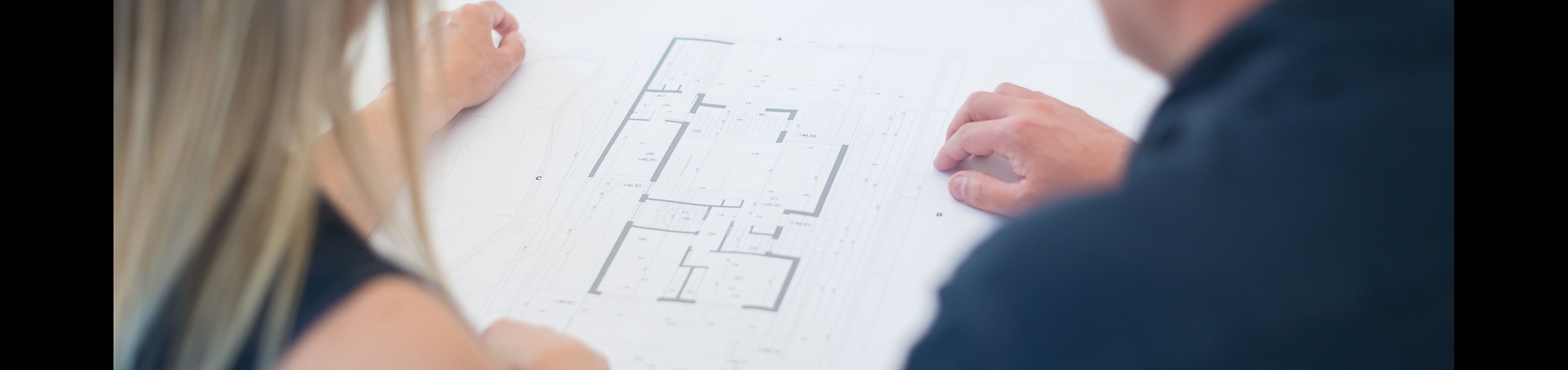Couple reviewing a modern apartment floor plan brimming with versatile living spaces.