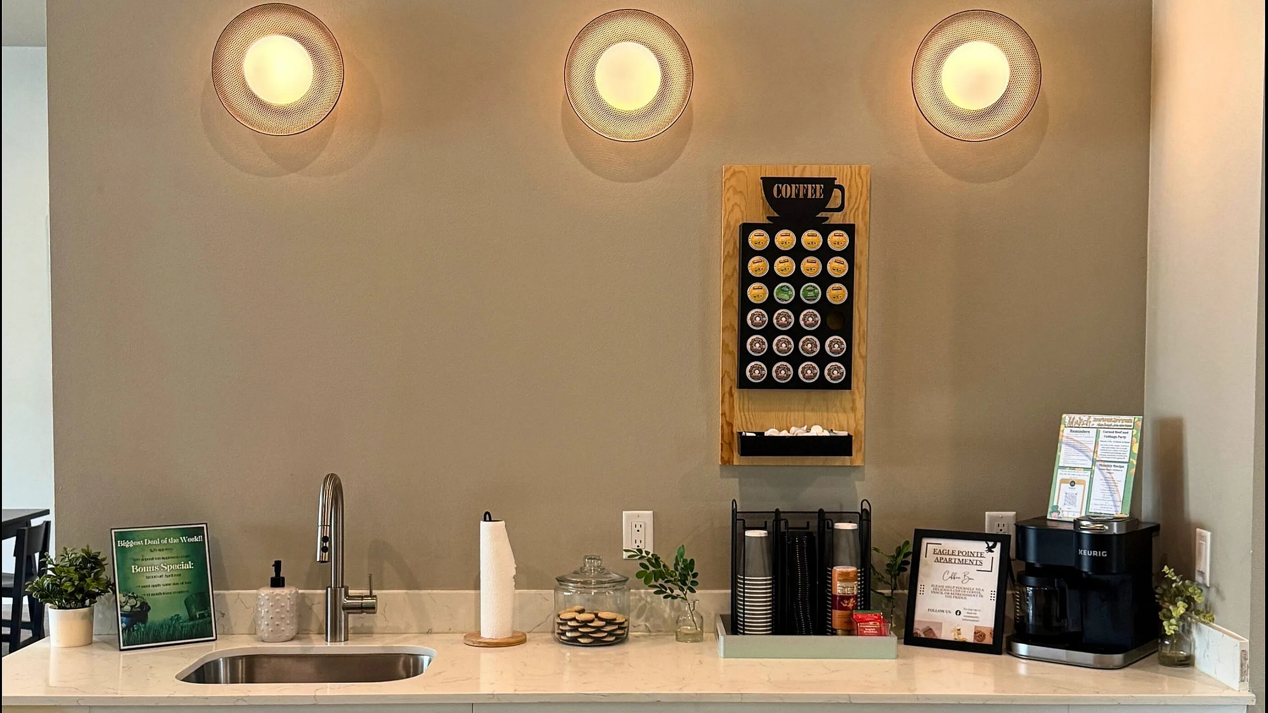 Inviting kitchen area with sleek coffee bar, modern fixtures, and elegant lighting, perfect for a cozy urban lifestyle.