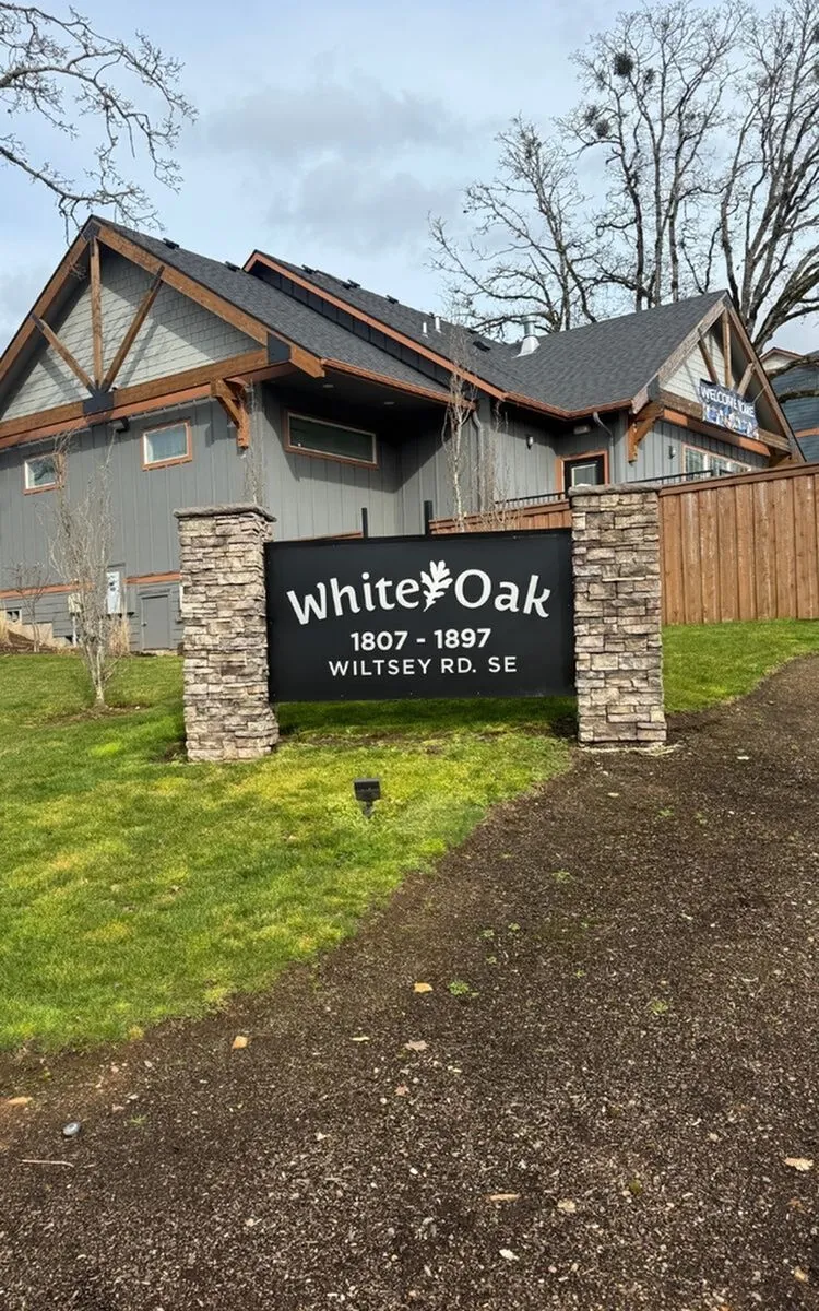 Charming rustic home with unique architectural design at White Oak, surrounded by lush greenery.