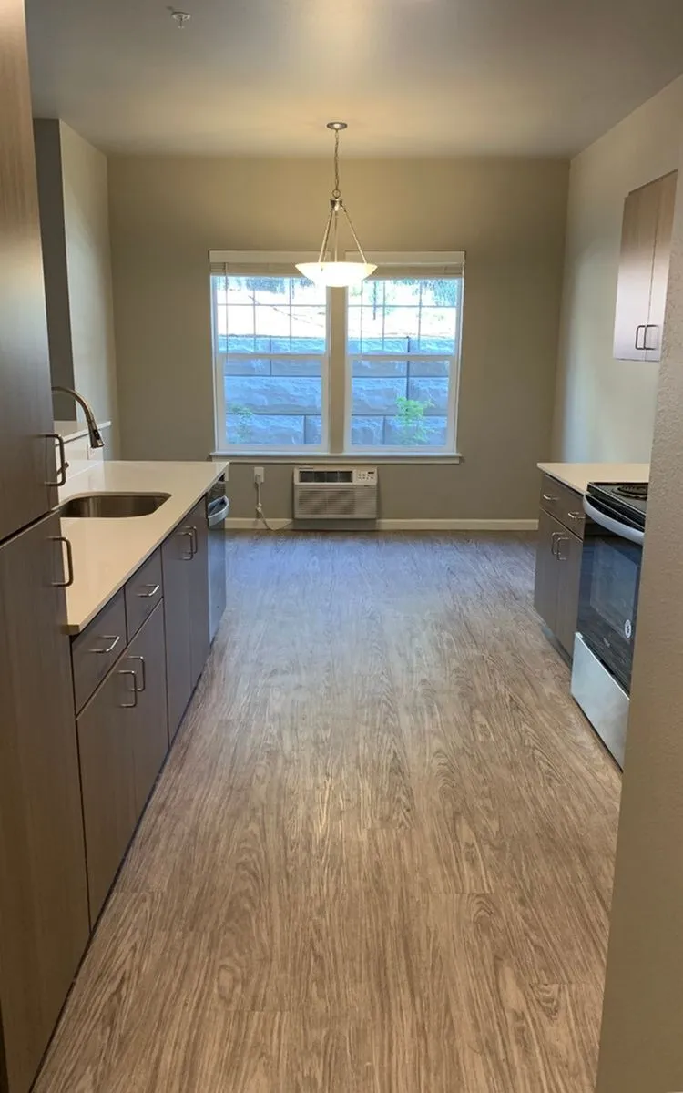 Chic and modern kitchen with sleek cabinetry, elegant countertops, and bright natural light through large windows.