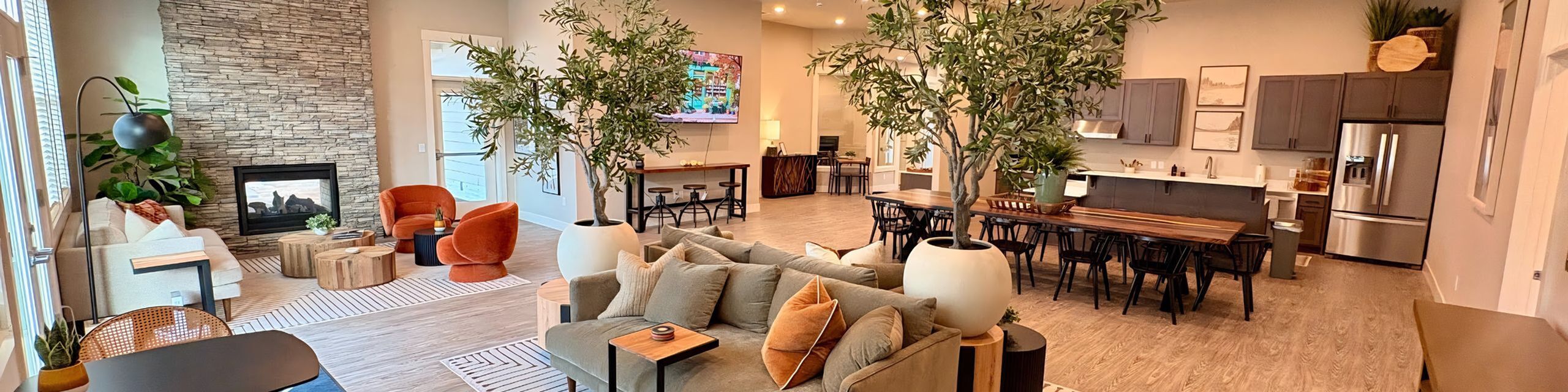 Elegant living space featuring a modern open-concept design with a cozy fireplace, stylish furniture, and a sleek kitchen area.