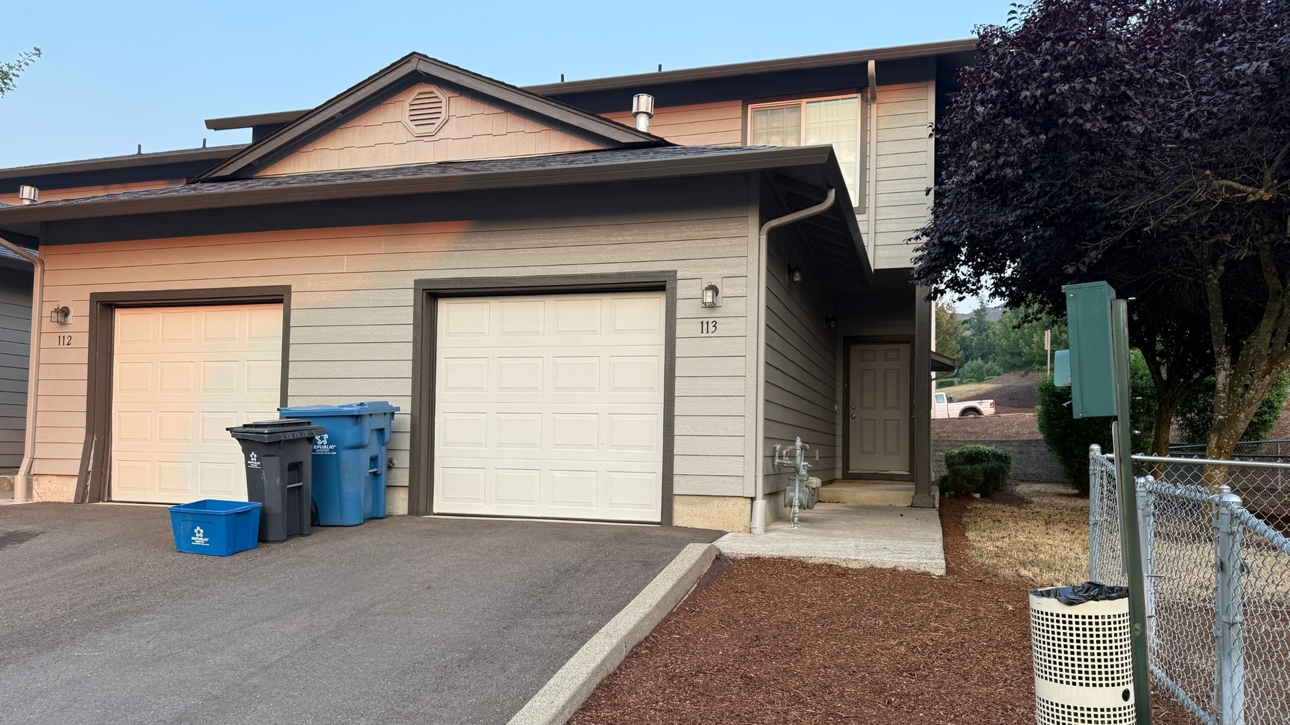 Charming townhouse featuring a modern facade with a two-car garage and a welcoming entrance, nestled in a serene neighborhood.