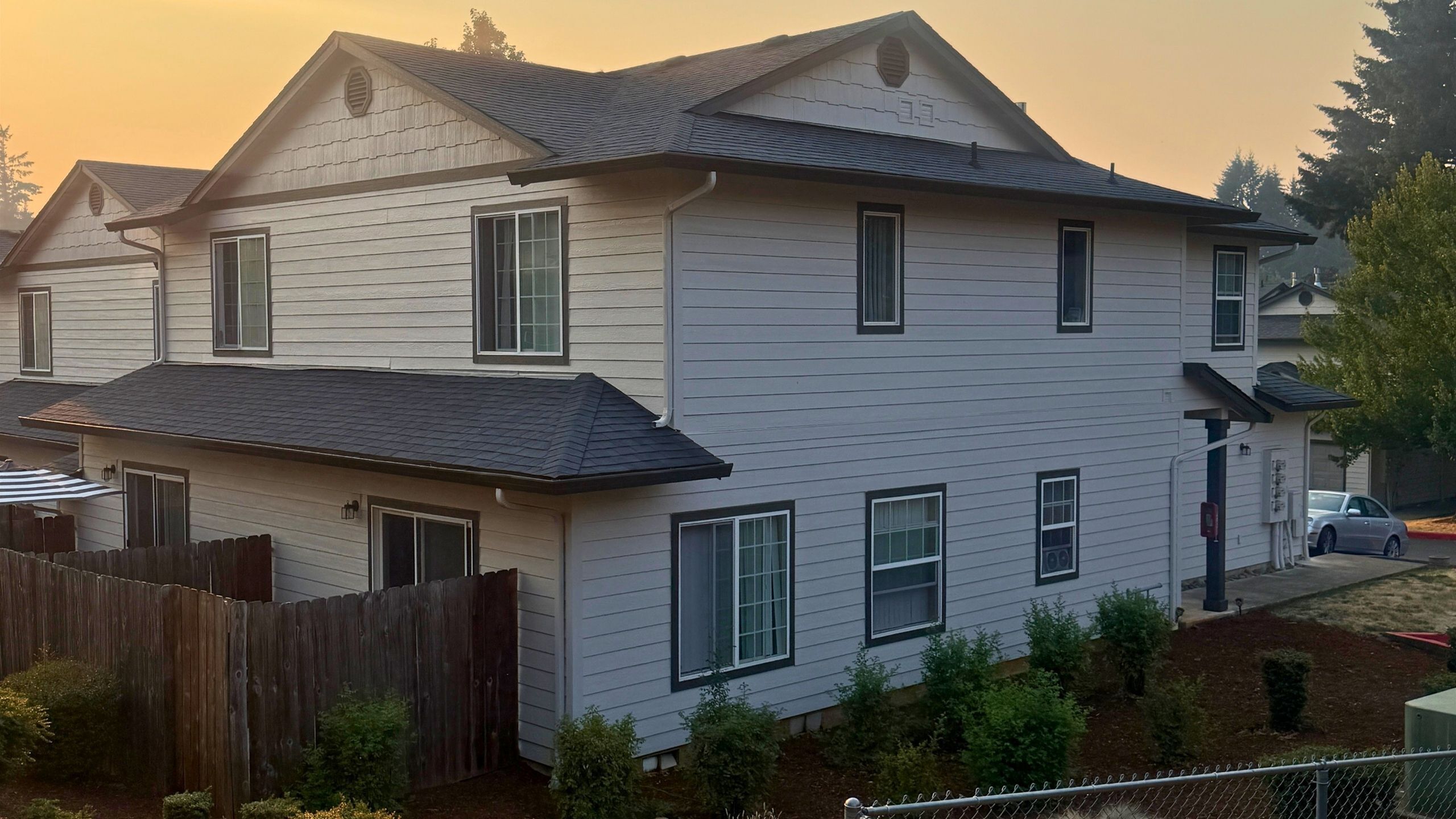 Charming two-story home with elegant siding and large windows, nestled in a quaint neighborhood setting.