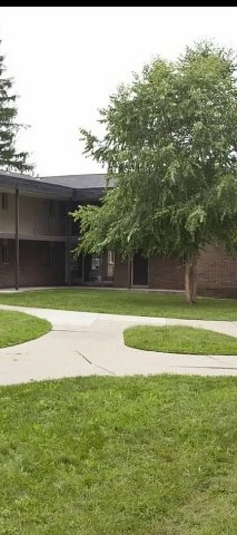 Charming apartment complex featuring lush green courtyards, brick facade, and serene pathways.
