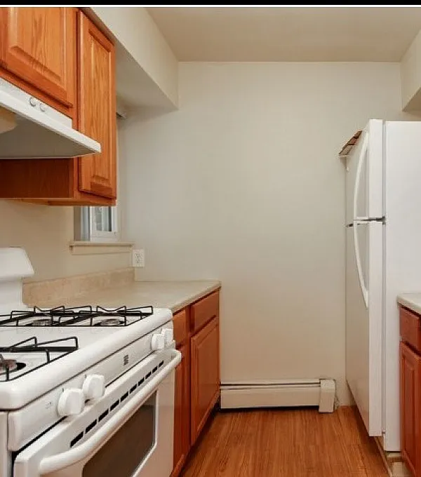 Charming kitchen with rich wooden cabinetry, sleek countertops, and modern appliances.