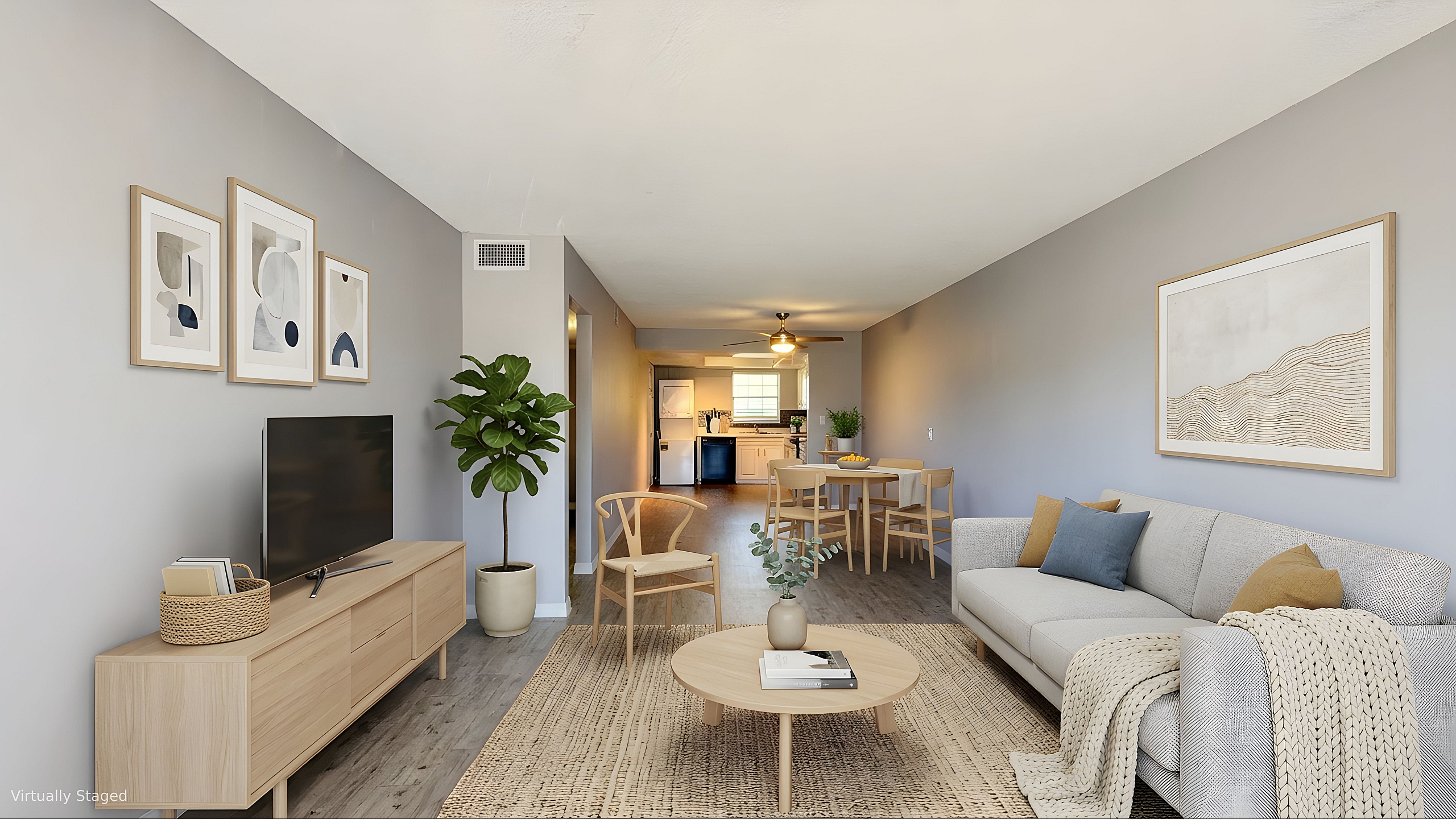 Modern open-concept living room with stylish decor, cozy seating area, and a sleek kitchen in the background, accentuated by warm tones and elegant furnishings.