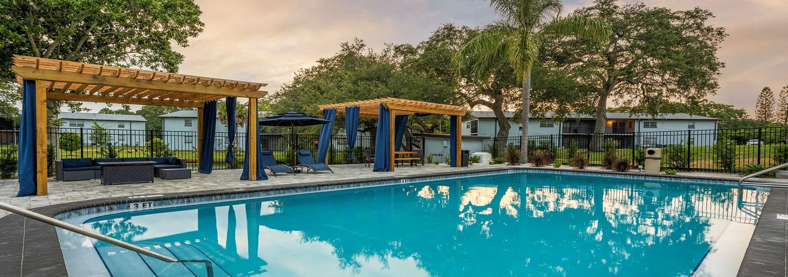 Inviting outdoor pool area with stylish pergolas, comfortable seating, and lush greenery, perfect for relaxation and leisure.