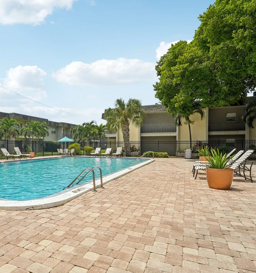 Inviting outdoor swimming pool surrounded by lush greenery, lounge chairs, and a serene atmosphere, ideal for relaxation.