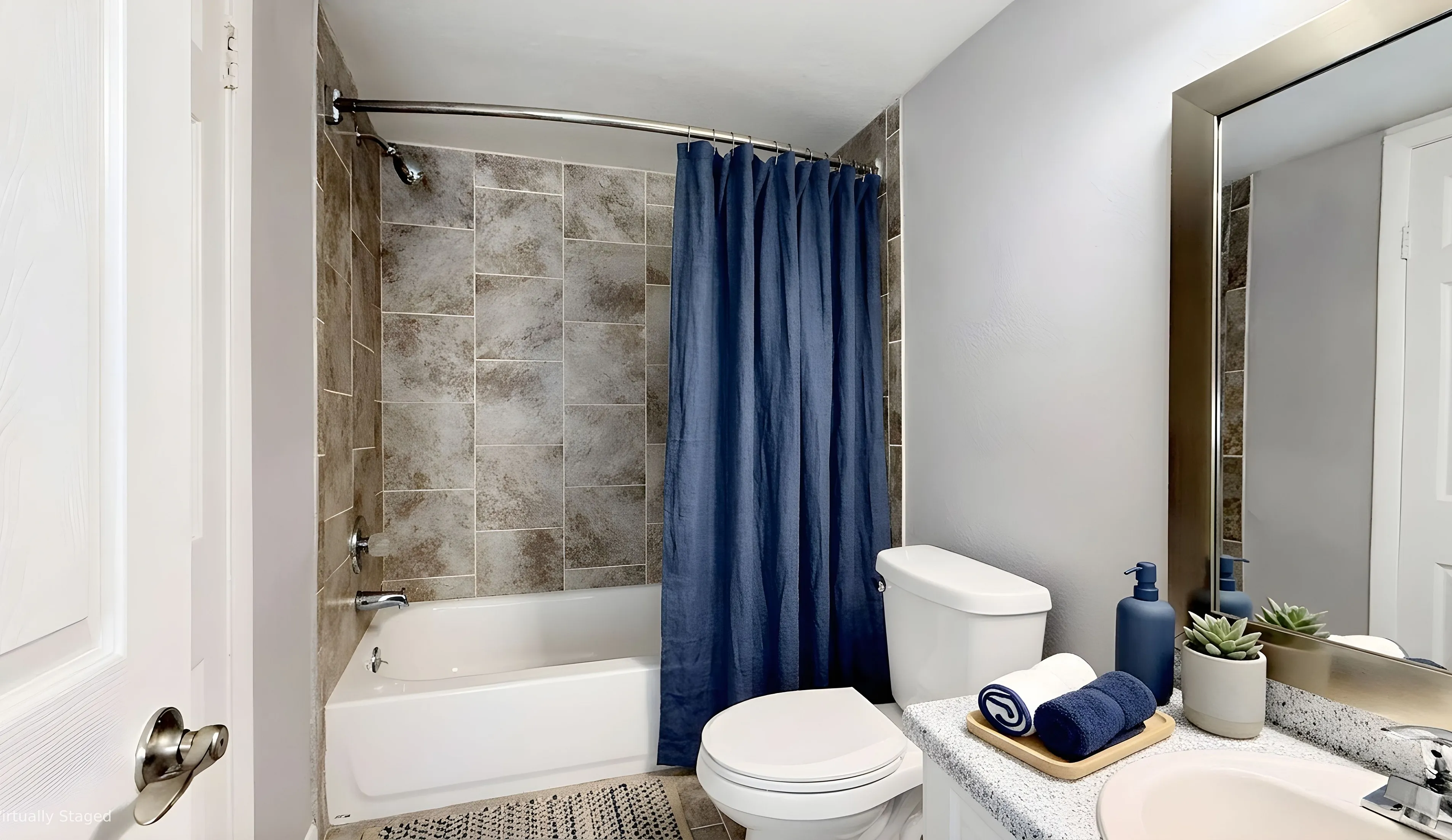 Chic bathroom with elegant tiled shower, modern fixtures, and stylish decor accentuated by a vibrant blue curtain.