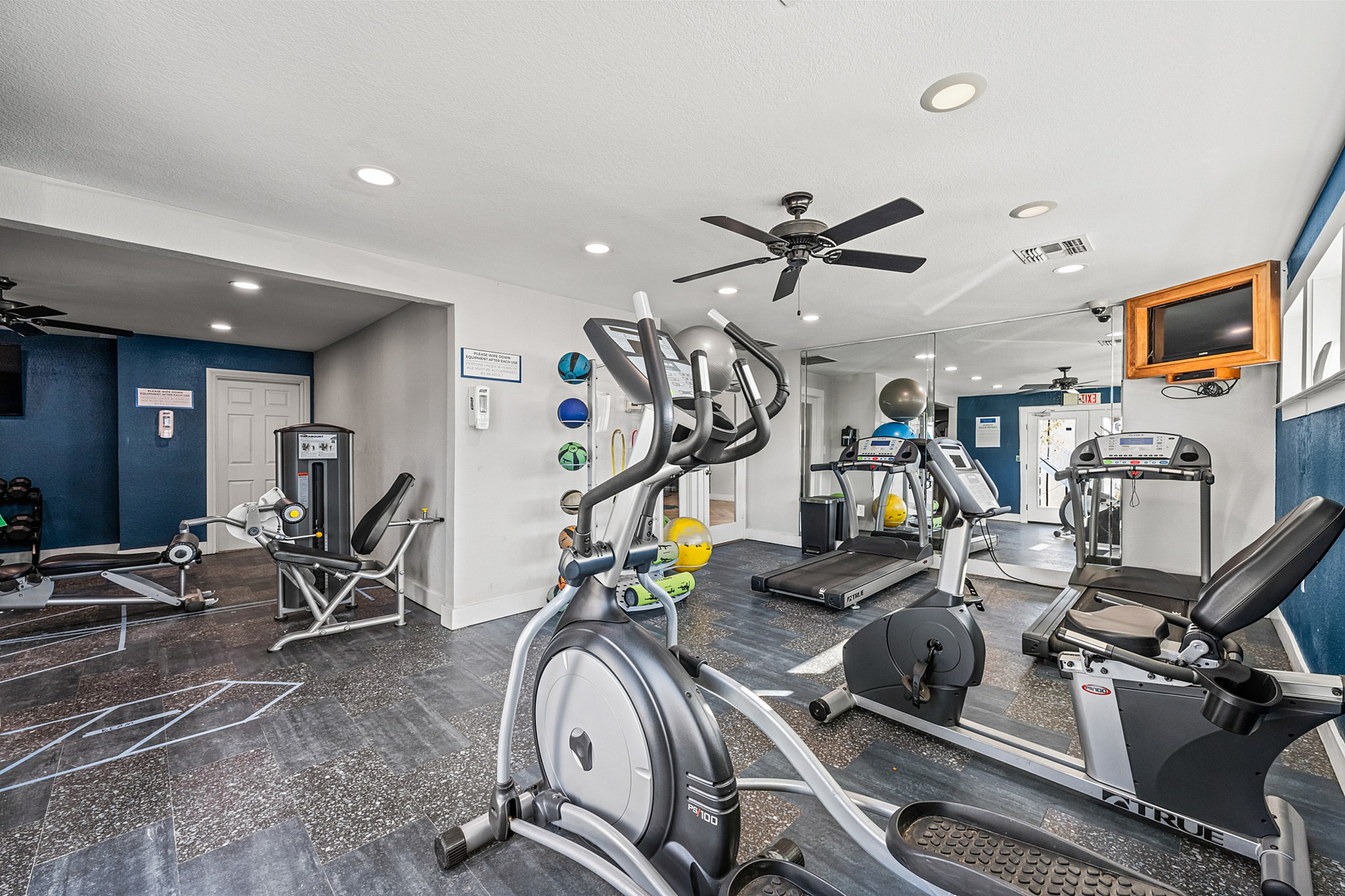 Modern apartment fitness center equipped with state-of-the-art exercise machines, bright ambiance, and motivational design.