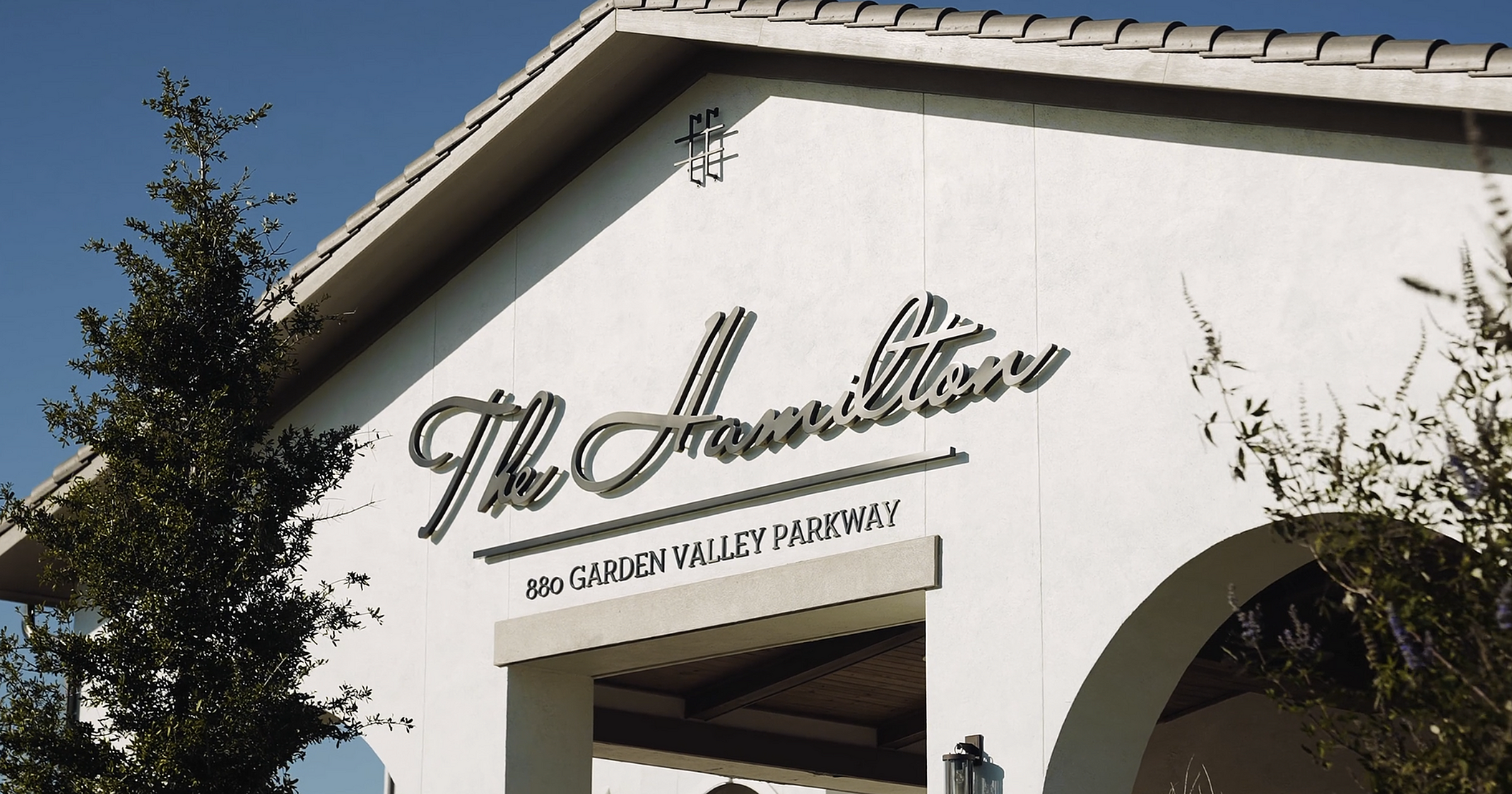 Elegant exterior of The Hamilton with stylish signage at 880 Garden Valley Parkway on a clear day.