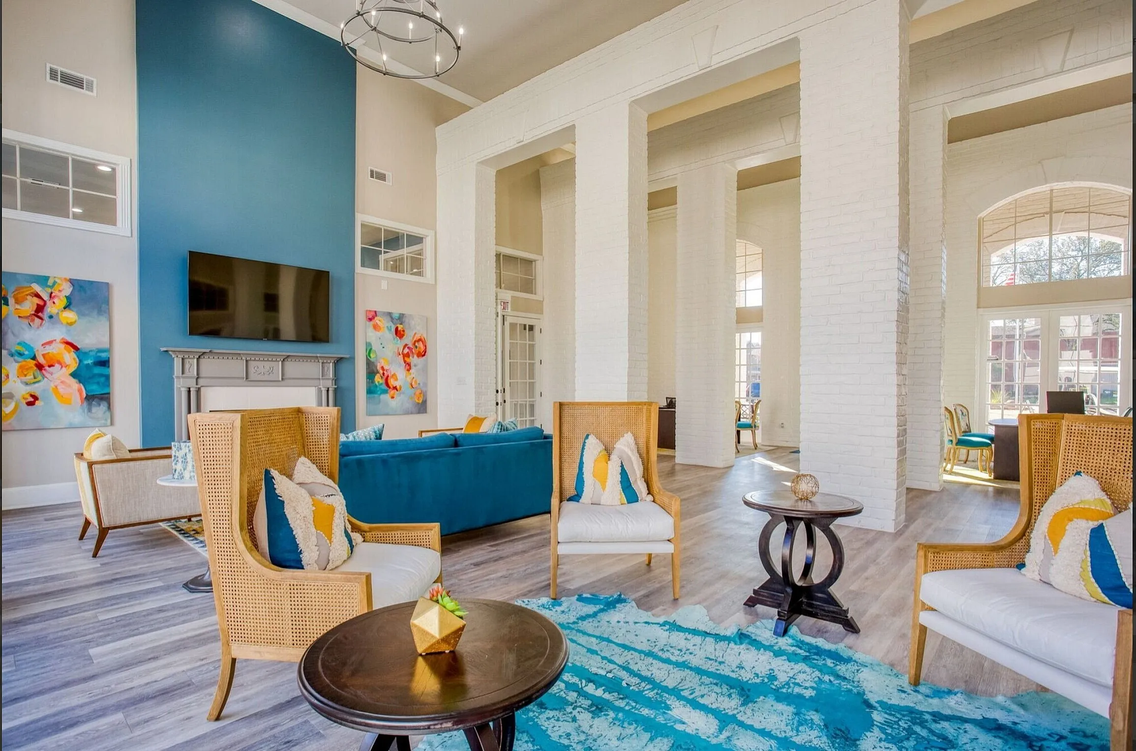 Elegant living space featuring chic blue accents, cozy seating, and vibrant artwork, perfect for relaxation and entertaining.