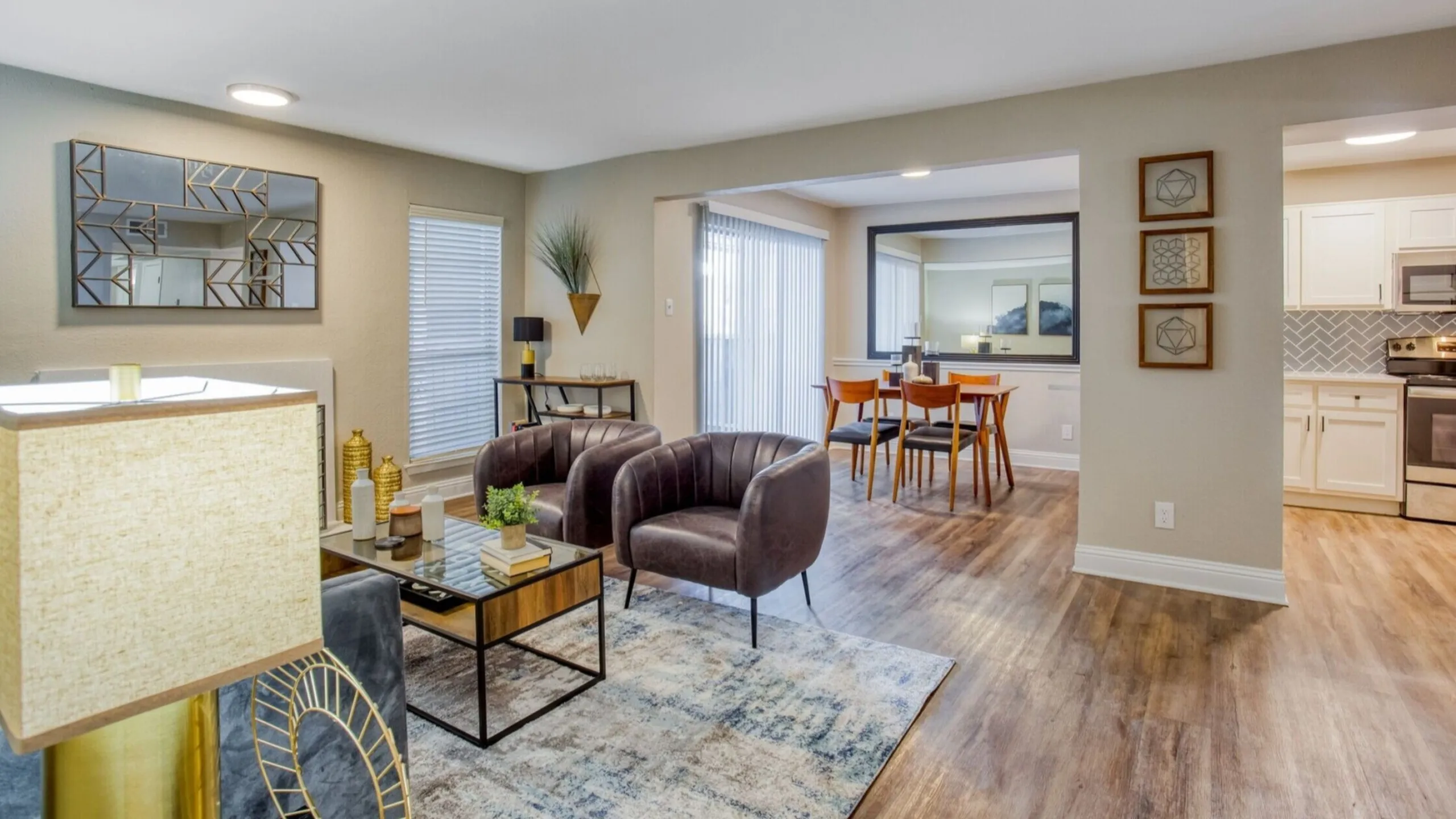 Chic open-concept living room and dining area with modern decor, sleek leather chairs, and stylish wood flooring.