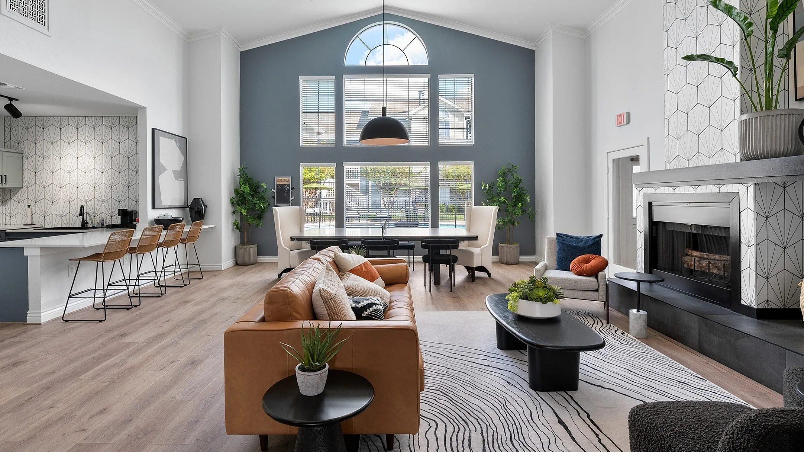Luxurious living room featuring high ceilings, stylish decor, and natural light creating a warm, inviting atmosphere with modern furniture and an elegant fireplace.