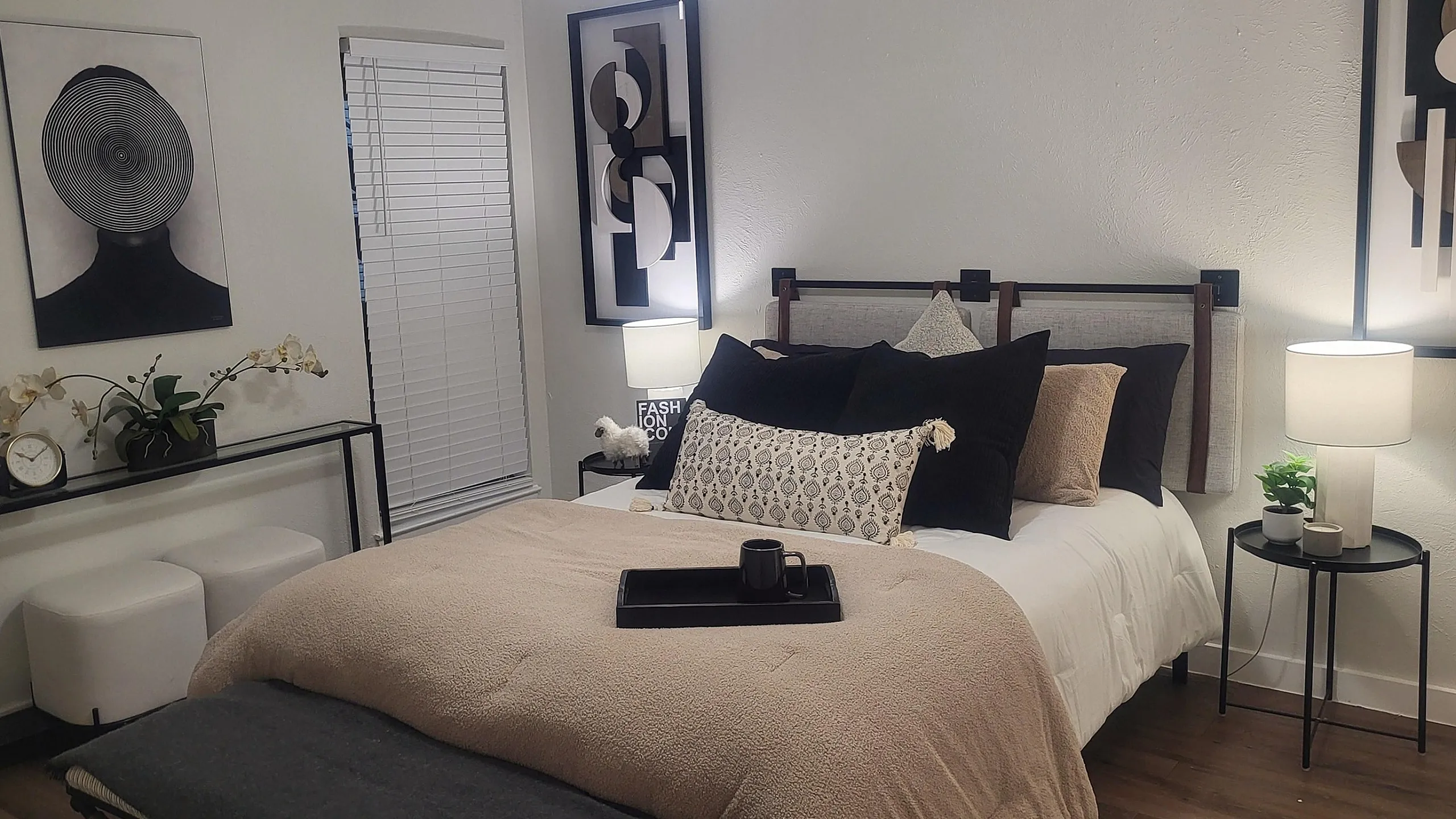 Elegantly designed bedroom with modern art, plush bedding, and cozy lighting, offering a serene and stylish retreat.