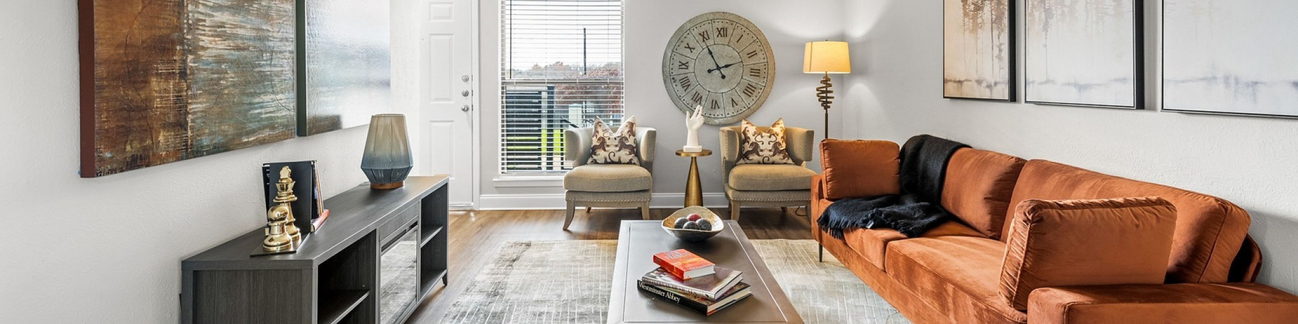 Bright and inviting living room with a stylish orange sofa, modern decor, and large windows offering natural light.