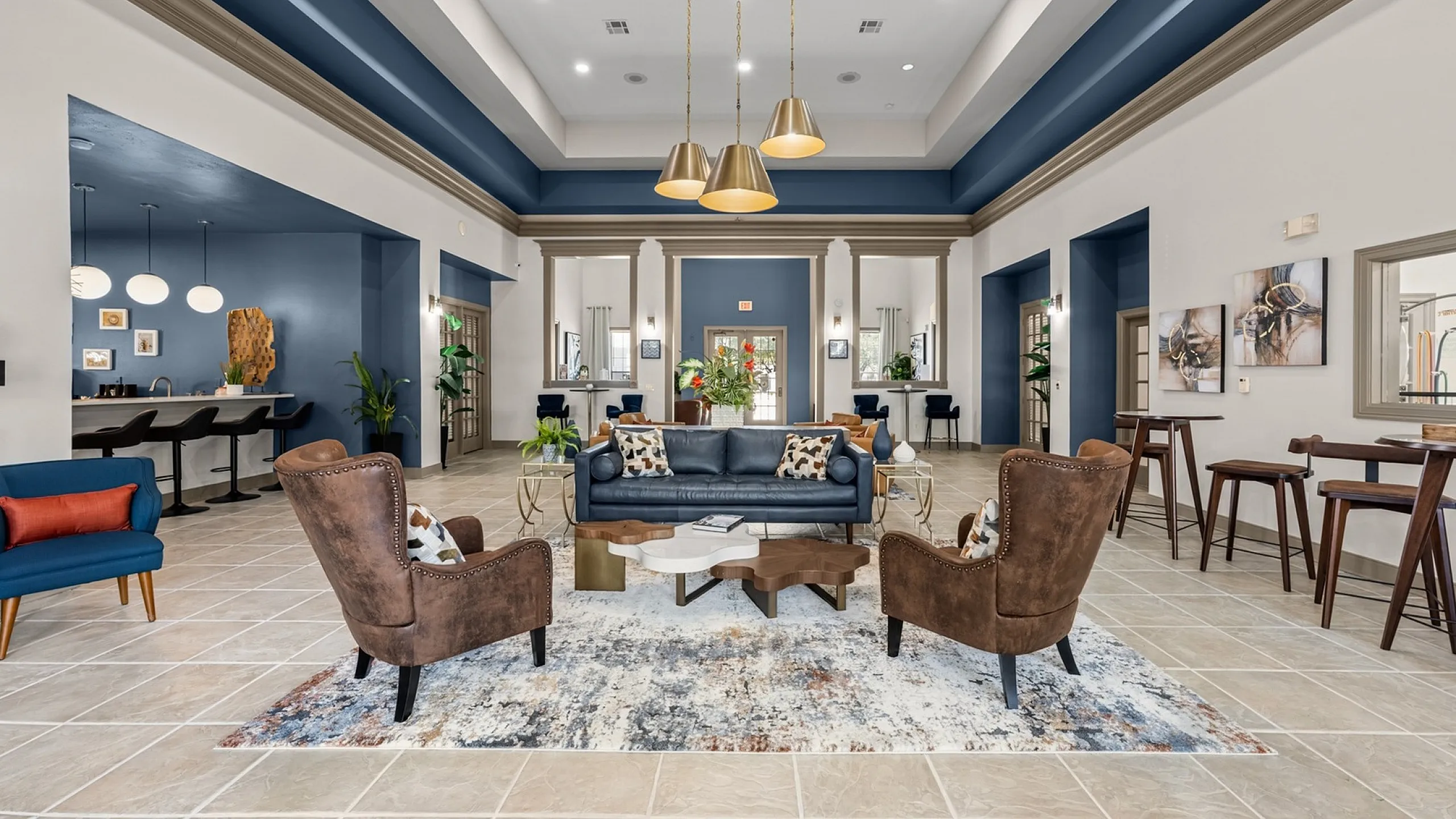 Elegant apartment lounge with luxurious seating, modern d&eacute;cor, and stylish lighting in a spacious, high-ceilinged room.